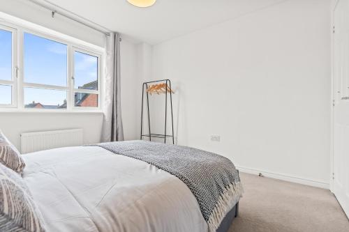 a white bedroom with a bed and a window at 247 Serviced Accommodation in Telford 4BR House in Telford