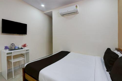 a bedroom with a bed and a tv on the wall at Super Collection O Sri Balaji Luxury rooms in Kondapur