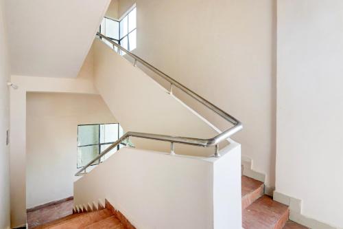 a staircase in a house with a metal handrail at Super Collection O Sri Balaji Luxury rooms in Kondapur