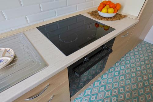 a kitchen counter with a sink and a bowl of fruit at Panoramico Appartamento Lido Conchiglie in Gallipoli