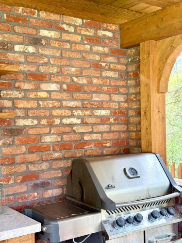 a grill sitting on top of a brick wall at Strużka Kaszuby - Leśniczówka w sercu Borów Tucholskich in Małe Swornegacie