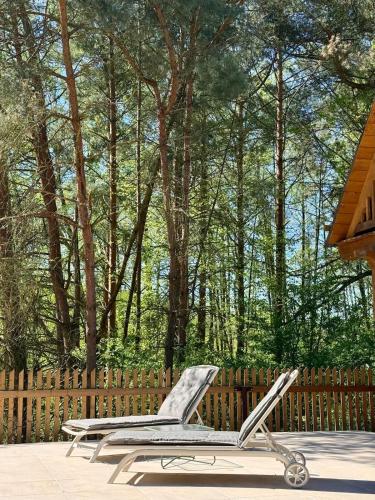 a chair sitting on a patio in front of a fence at Strużka Kaszuby - Leśniczówka w sercu Borów Tucholskich in Małe Swornegacie