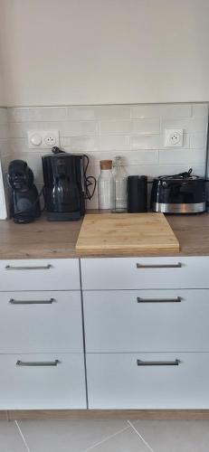 une cuisine avec des armoires blanches et un comptoir en bois dans l'établissement Cabestan air-conditioned Marina opposite the shops near the North Beach, au Grau-du-Roi