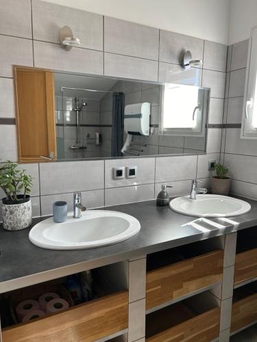 une salle de bain avec deux lavabos et un grand miroir dans l'établissement Gîte la Villa Cerisier, à Cabasse