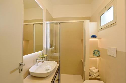 a white bathroom with a sink and a shower at Panoramico Appartamento Lido Conchiglie in Gallipoli