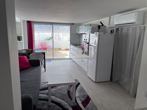 Il comprend une cuisine et un salon avec un réfrigérateur blanc. dans l'établissement duplex en bord de mer, à Cagnes-sur-Mer