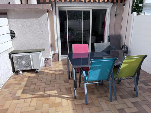 d'une terrasse avec une table, des chaises et un radiateur. dans l'établissement duplex en bord de mer, à Cagnes-sur-Mer