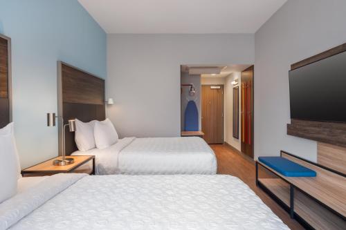 a hotel room with two beds and a flat screen tv at Tru By Hilton Houston Downtown Convention Center in Houston