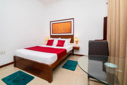 a bedroom with a bed and a glass table at Colour Moon Hotel in Kotagala