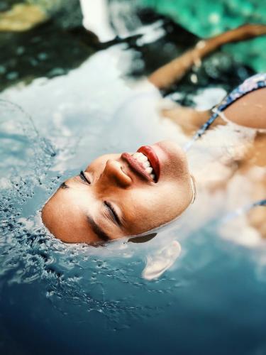 a young man in a swimming pool at Gaarten Hotel Benessere Spa by Kleos Group Collection in Gallio