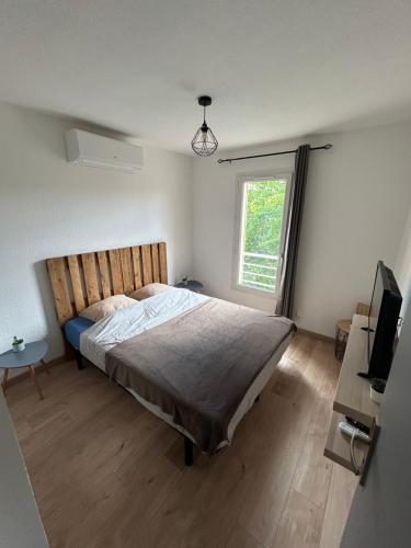 une chambre avec un grand lit et une fenêtre dans l'établissement Maison 4 pers proche du centre, à Vaison-la-Romaine