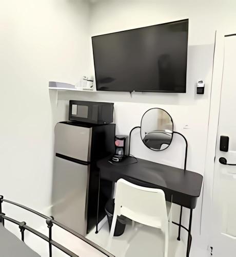 a black table with two chairs and a television on a wall at Gorgeous Private Room, near the Airport - Free parking - 01 in Miami