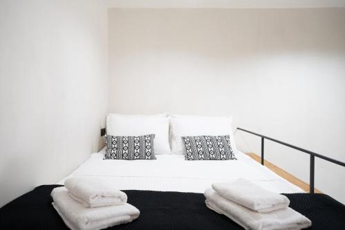 a white bed with two pillows and towels on it at Mykonos Nest-Stylish Boho Loft in the heart of Chora 2-4 Guests in Megali Ammos