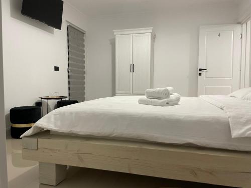 a white bedroom with a bed with towels on it at AGM Home in Cajvana