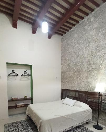 Cette chambre blanche comprend un lit et un miroir. dans l'établissement Casa Al Mar, à Campeche
