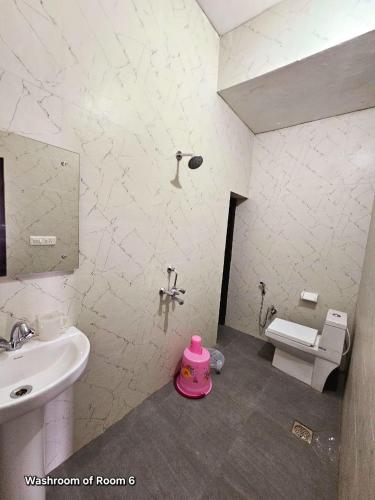 a bathroom with a sink and a toilet and a sink at Ved Homestay in Dehradun