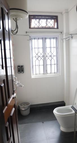 a bathroom with a toilet and a window at The LYNMAR HOMESTAY at Mawkynroh in Shillong
