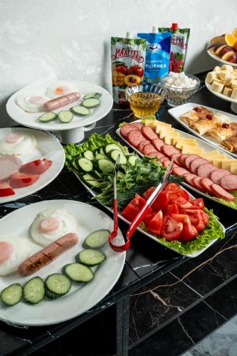a buffet with plates of food on a table at Urban Hotel in Almaty