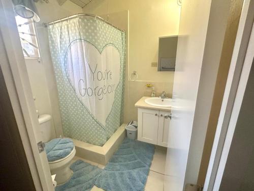 a bathroom with a shower with a heart shower curtain at Spring Top Cottage in Falmouth