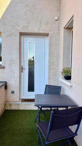 - une table de pique-nique et deux chaises devant une porte dans l'établissement Studio Prenois, à Prenois