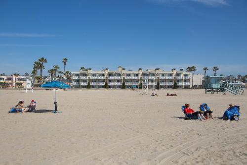 a group of people sitting in chairs on the beach at Beach House Hotel at Hermosa Beach in Hermosa Beach