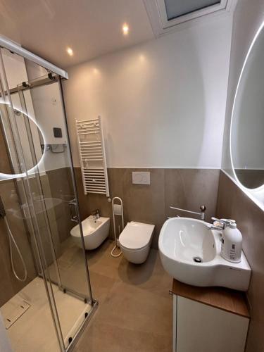 een badkamer met een wastafel, een toilet en een douche bij Villa Giny in Lignano Sabbiadoro