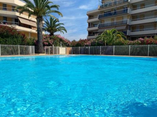 une grande piscine bleue devant un immeuble dans l'établissement Fréjus plage appartement La Miougrano, à Fréjus