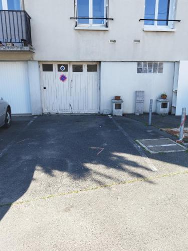 - un parking en face d'un bâtiment blanc dans l'établissement Appartement T3, à Joué-lès-Tours