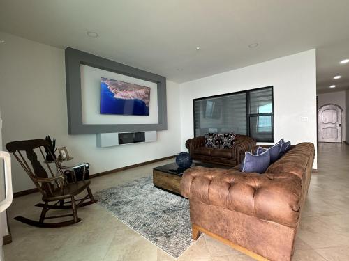 una sala de estar con un sofá y una silla en Mar y Sol 16th floor Condo, en Rosarito