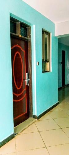 a red door in a room with a blue wall at Kanaprime Hotels & Safaris Shanzu pride in Mombasa