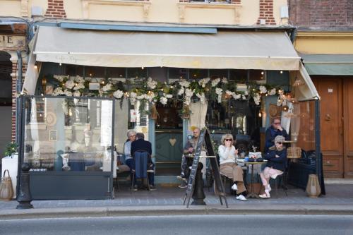 a group of people sitting outside of a restaurant at Les Demoiselles in Honfleur