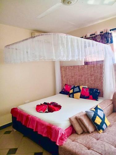 a bedroom with a bed with a canopy at Shanzu Pride Studio Apartment Mombasa in Mombasa