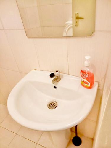 a bathroom sink with a bottle of soap on it at Kanaprime Hotels & Safaris Shanzu pride in Mombasa