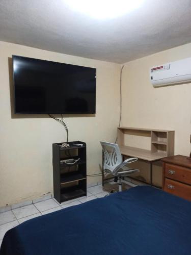 a bedroom with a bed and a television on the wall at Casa GUAYMAS 01 in Guaymas