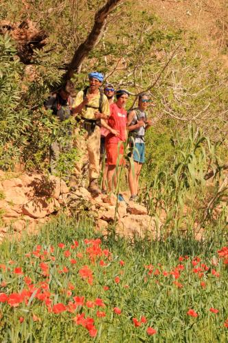 a group of people standing on a rock in a field of flowers at Casbah d'hôte La Jeanne Tourisme Ecologique in Boumalne
