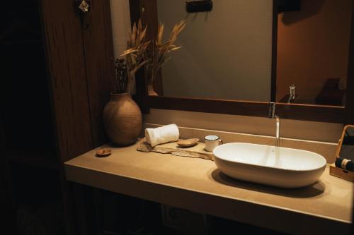 a bathroom counter with a sink and a mirror at Vila Cerrado in Alto Paraíso de Goiás