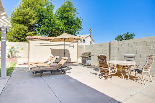 a patio with a table and chairs and an umbrella at Pool, Patio and Hot Tub Surprise Home Near Golfing! in Surprise