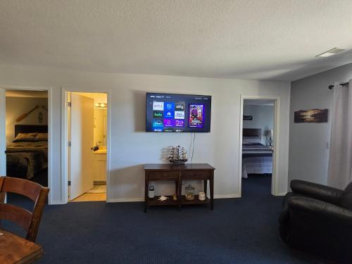 a living room with a couch and a tv on the wall at Swan's Getaway Lakeview Condo in Kimberling City