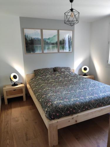 une chambre avec un lit et deux tables de nuit dans l'établissement NEW - Jardin - Proche Briançon Serre Che - Vue montagne - Ski, à Villar-Saint-Pancrace