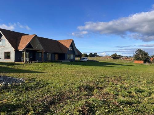 a house with a large field in front of it at Casa en parcelación pichilaguna, Llanquihue in Llanquihue