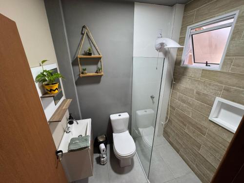 ein kleines Badezimmer mit Toilette und Dusche in der Unterkunft Breeze Floripa - Campeche in Florianópolis