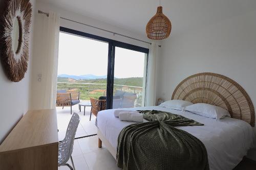 une chambre avec un lit et une grande fenêtre dans l'établissement T3 Villas Acum - Le Bohème - Excellente situation géographique - domaine de Standing - Vue mer, à Grosseto-Prugna