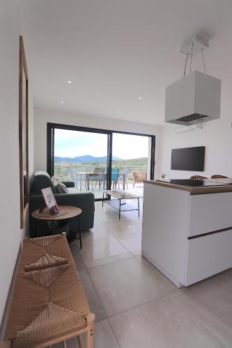 une cuisine et un salon avec un canapé et une table dans l'établissement T3 Villas Acum - Le Bohème - Excellente situation géographique - domaine de Standing - Vue mer, à Grosseto-Prugna