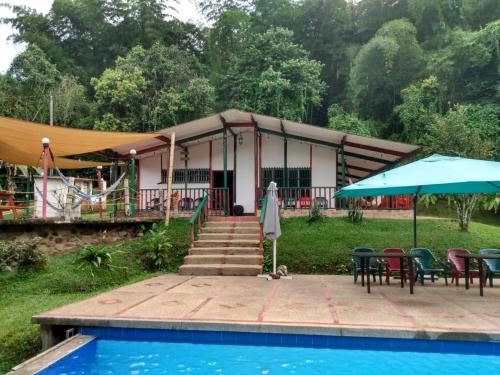 a resort with a pool and tables and a tent at Casa quinta del 11 in La Vega