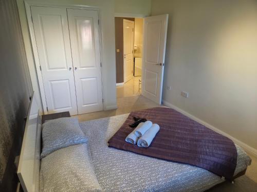 a bedroom with a bed with two towels on it at Solihull Centre Apartments in Solihull