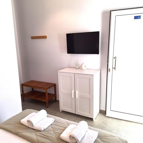 a bedroom with a bed and a flat screen tv at Villa Thalassa Apartments in Pefkochori
