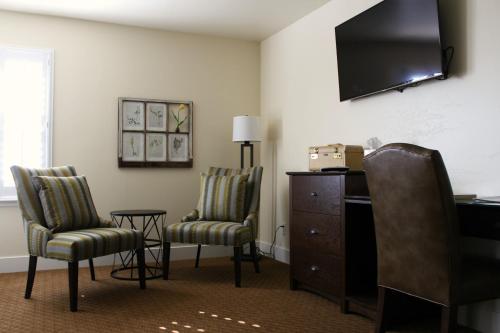 a room with two chairs and a dresser and a television at Rest, a boutique hotel in Plymouth
