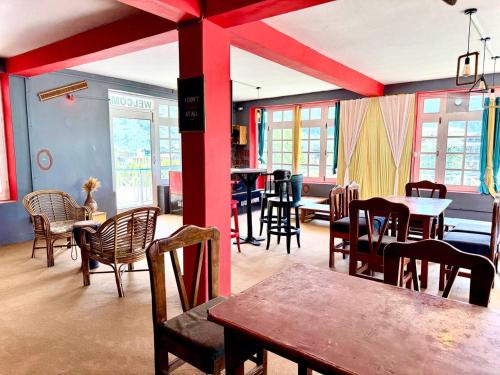 a dining room with tables and chairs and windows at Hotel The Premium Villa Old Manali View in Manāli