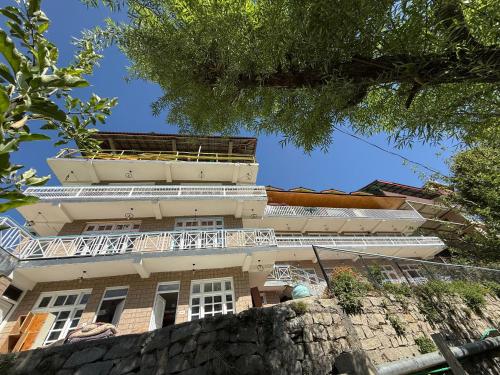 a building with a balcony on top of it at Hotel The Premium Villa Old Manali View in Manāli