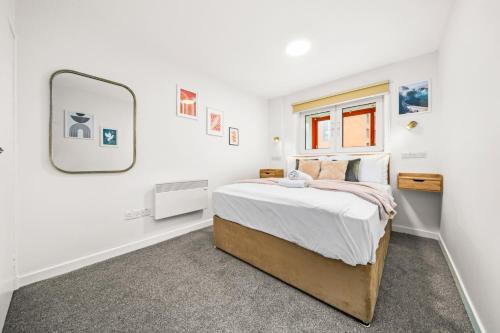 a bedroom with a bed and a mirror at Stylish Central Glasgow Flat Near Merchant City in Glasgow